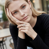 Anillo en plata AC4 de la colección Candela sobre un fondo de color