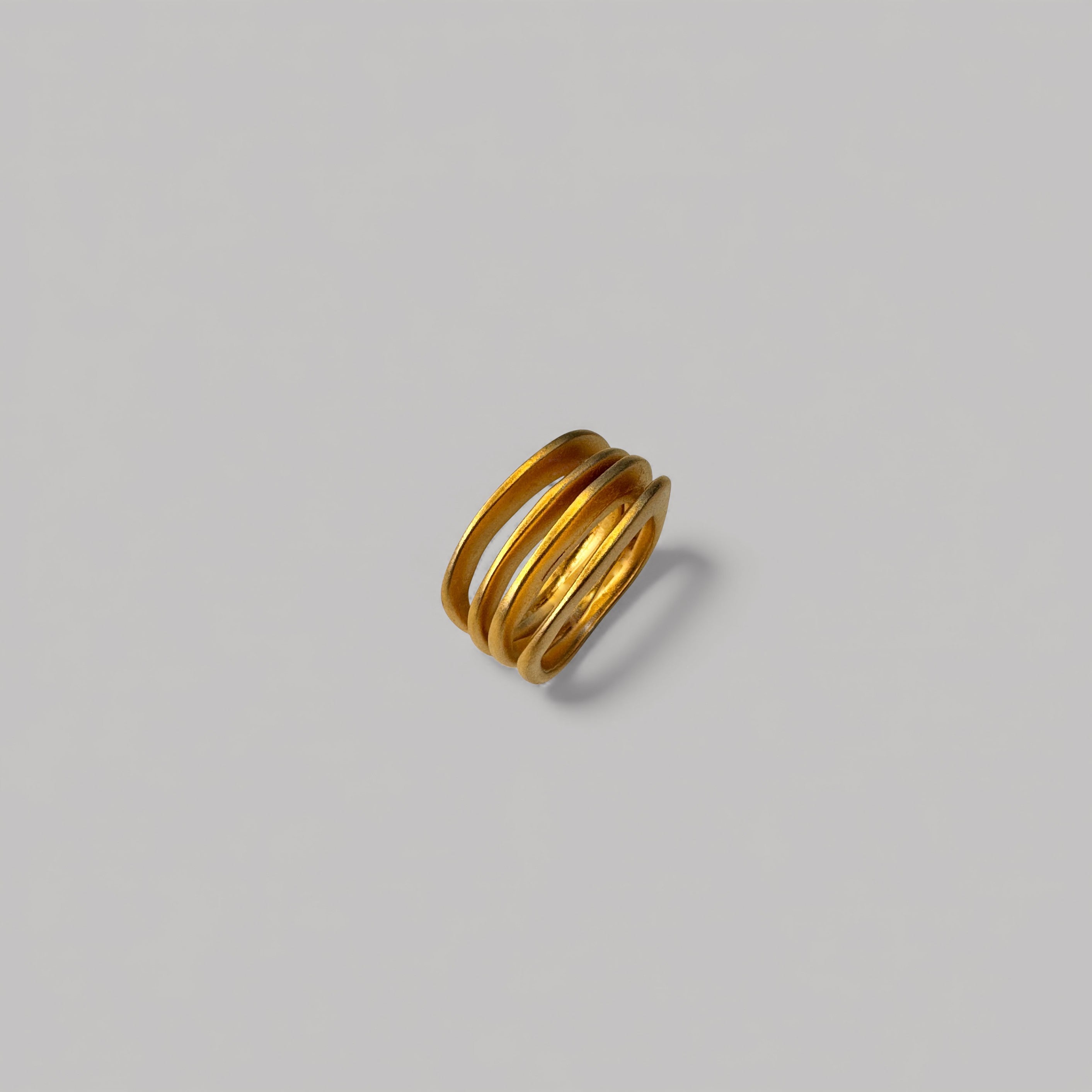 Anillo en oro AC4G de la colección Candela sobre un fondo de color