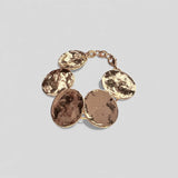 Pulsera en oro BA2G de la colección Abril sobre fondo de color