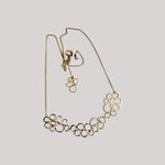 Gargantilla en oro CB2 de la colección   Brisa sobre fondo de color