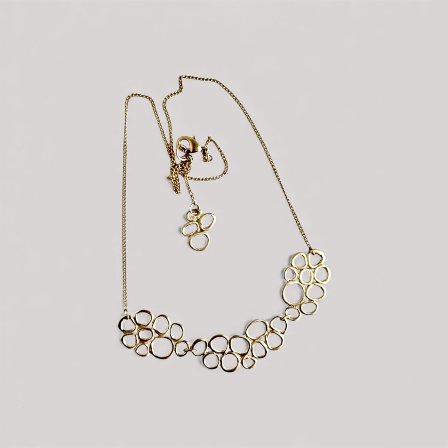 Gargantilla en oro CB2 de la colección   Brisa sobre fondo de color