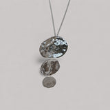 Colgante en plata CA2S de la colección ABRIL sobre un fondo de color