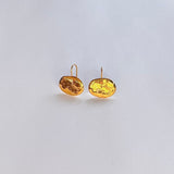 Pendientes en oro PA2 de la colección Candela sobre fondo de color