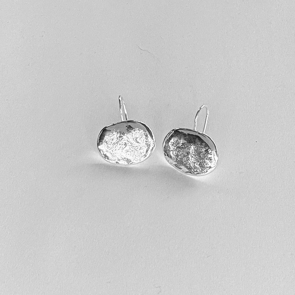 Pendientes en plata PA2 de la colección Candela sobre fondo de color