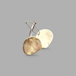 Pendientes en oro mate PM7G de la colección Martina sobre un fondo liso con reflejos