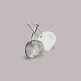 Pendientes en oro mate PM7G de la colección Martina sobre un fondo liso con reflejos