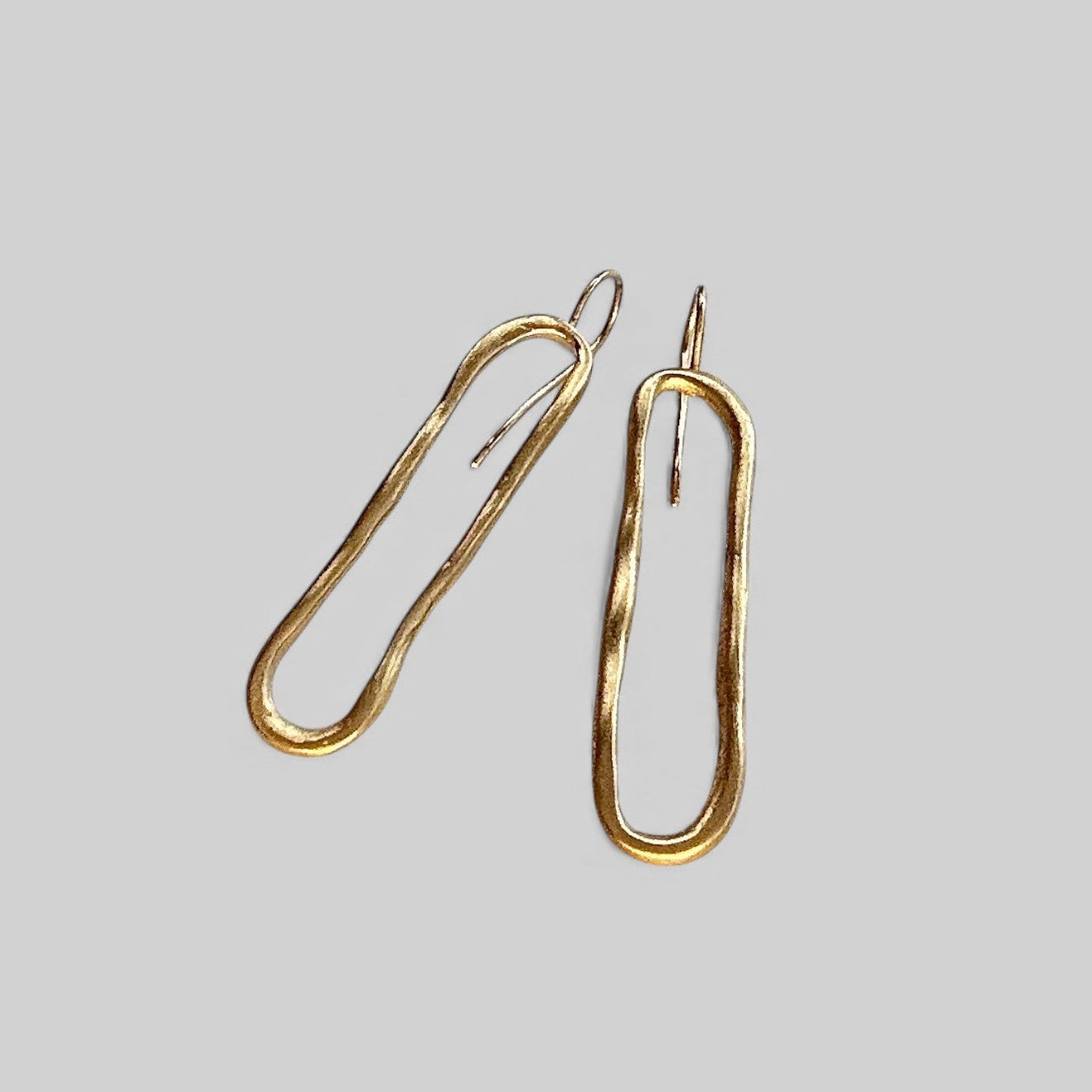 Pendientes en oro PC1 de la colección Candela sobre fondo de color