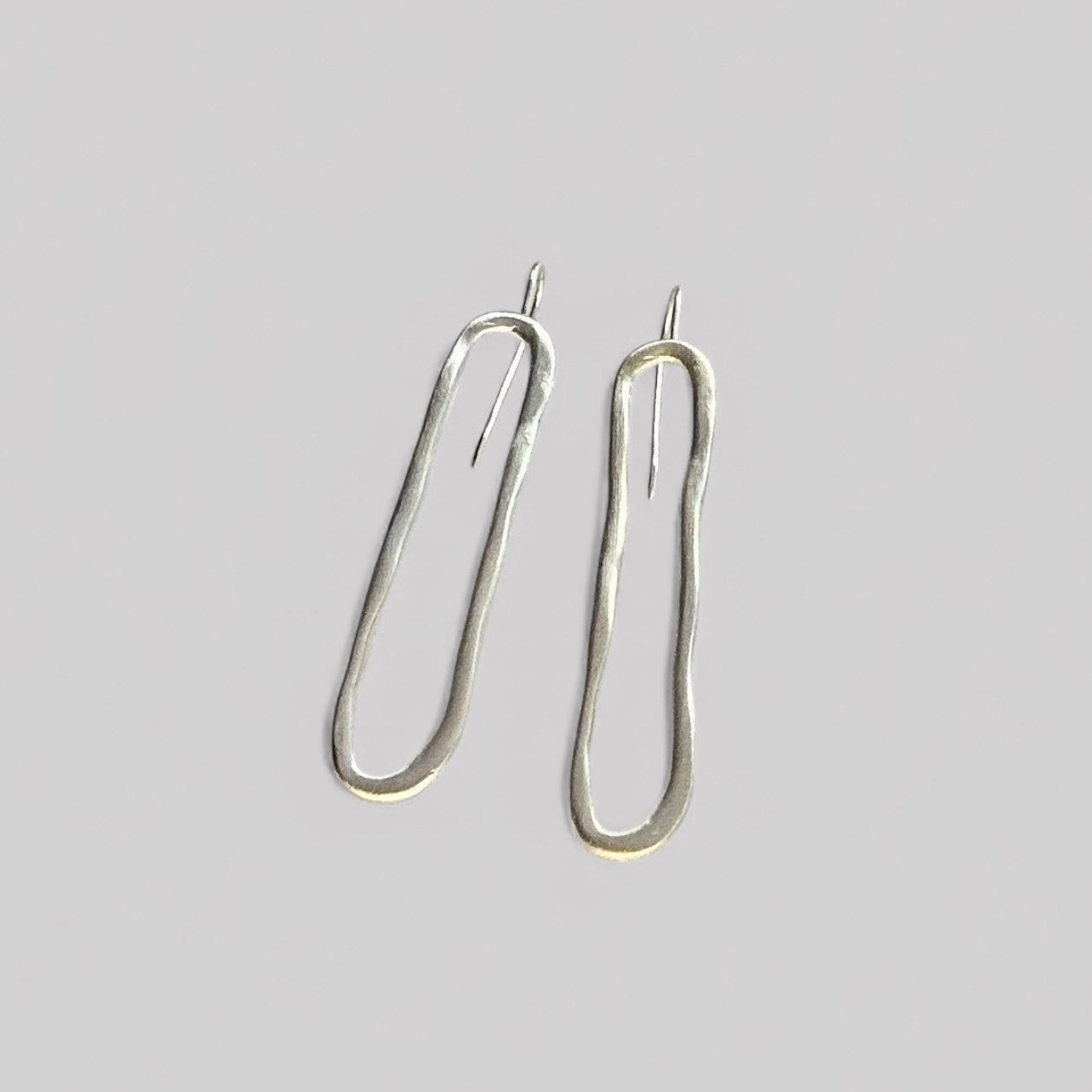 Pendientes en plata PC1 de la colección Candela sobre fondo de color