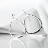Pendientes en plata PC5 de la colección Candela sobre un fondo liso con sombra