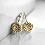 Pendientes en oro mate PB4SS de la colección Brisa sobre fondo liso con reflejo