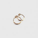 Pendientes en oro mate PM3GS de la colección Martina sobre fondo liso con fondo de color